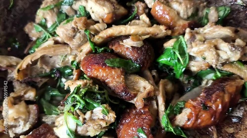 Stir-fried roasted duck with basil in pan, indoor Chiangmai Thailand.
