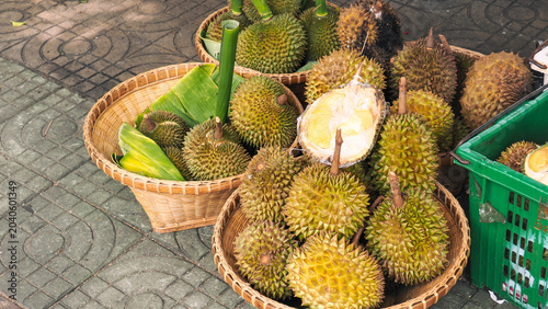 Fresh durian fruits with spiky shell for sale in bamboo baskets on street market