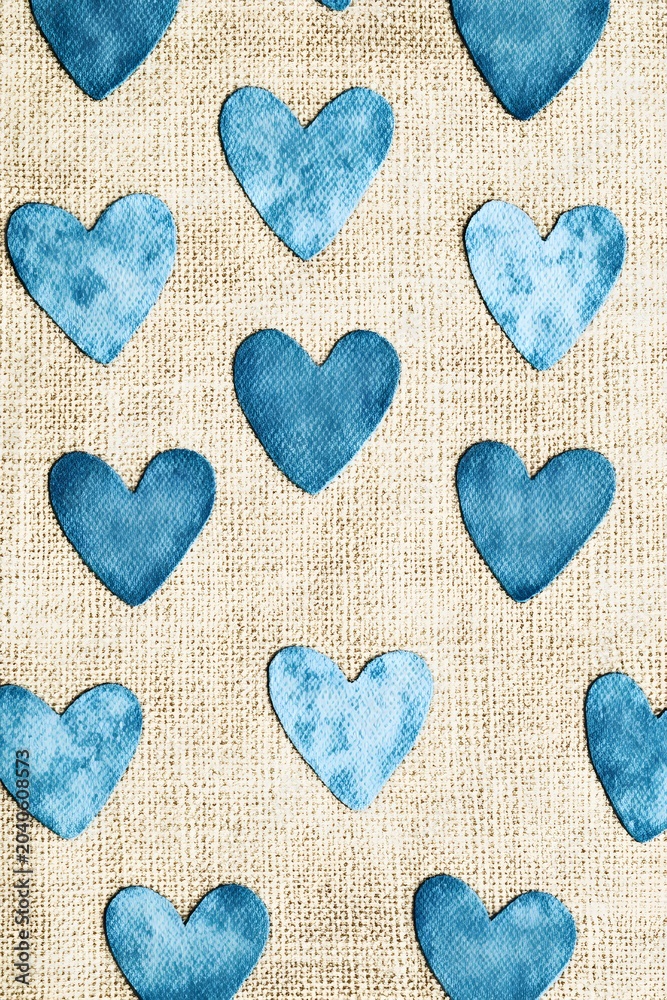 Obraz premium Blue heart pattern on textured burlap background