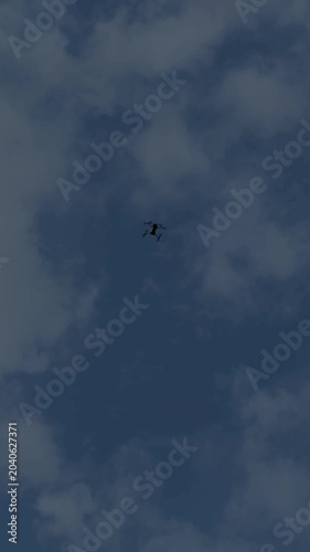 Drone Hovering Motionless Against Blue Sky. Modern drone hovering steadily in the sky with clear blue background.