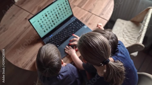Overhead view of parent and child using laptop on wooden table, cozy living room light, hands on keyboard, focused tutoring moment, subtle emotional bond, stepbystep guidance, modern digital