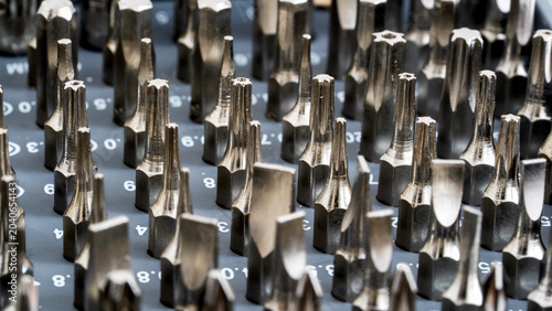 Metallic screwdriver bits arranged in neat rows