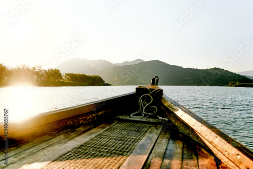 Quadro su tela Wooden boat yacht sailing on water Skadar Lake in Montenegro, summer landscape