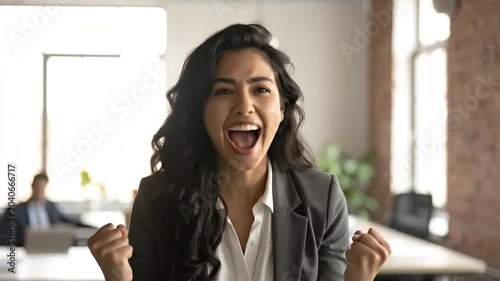 A happy professional woman celebrates a successful achievement in the office