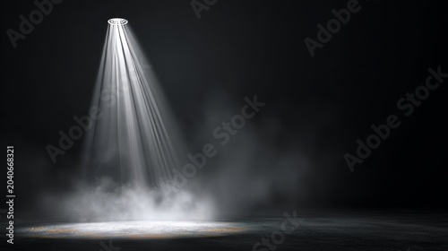Spotlight beam illuminating dark stage floor with smoke, dramatic lighting.