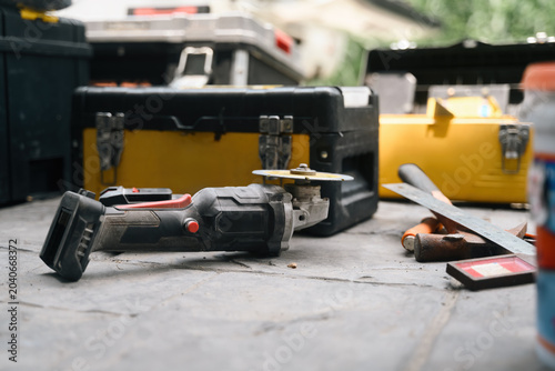 Foto Cordless Power Tool and Yellow Toolboxes on Concrete Floor at Construction Site