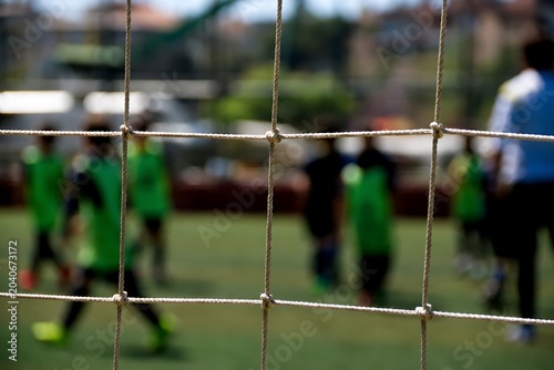 Soccer goal net with blurry players.