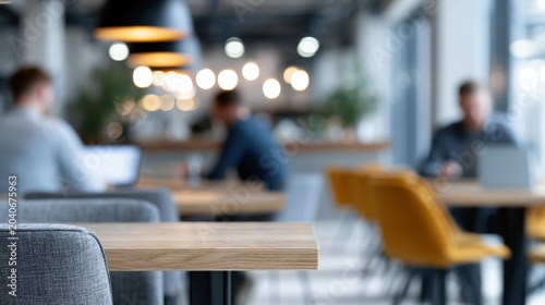 Stylish coworking coffee shop with blurred creative professionals using laptops, modern productivity atmosphere