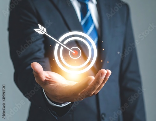 A man in business attire holds a glowing target with an arrow
