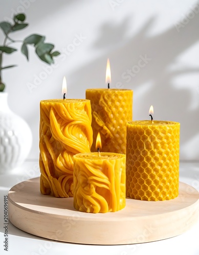 Four yellow candles on a wooden plate