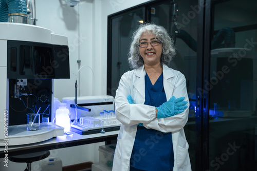 Successful female doctor or scientists standing at table, looking at camera.