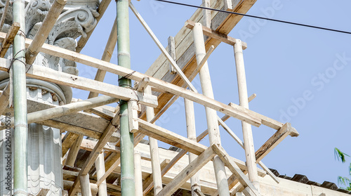 Tableau sur toile Bamboo scaffolding surrounding a classical architectural column during building