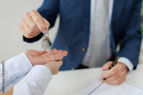 Foto Real estate agent handing over house keys to a new property owner, symbolizing s