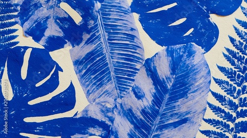 Abstract background featuring blue painted leaves and ferns arranged artistically on a light surface, showcasing intricate textures and patterns