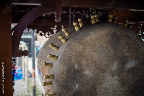 Photos Close-up low angle view of a large traditional Bedug drum, highlighting brass pegs and weathered drumhead texture