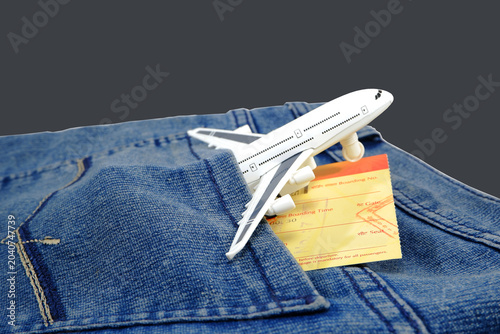 Tableau sur toile A miniature white airplane model rests on a blue jeans with a yellow boarding pass peeking out of the pocket, suggesting travel plans and adventure