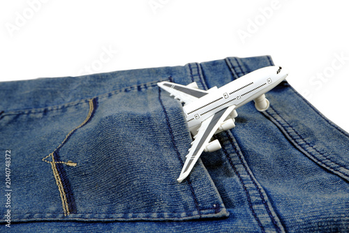 Photos A small white airplane is placed inside the pocket of blue denim jeans, suggesting travel or a journey contained within everyday clothing, creating a whimsical and unexpected juxtaposition