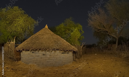 Photos Central Africa, Chad, Night view of a village courtyard with brick huts and wooden light buildings