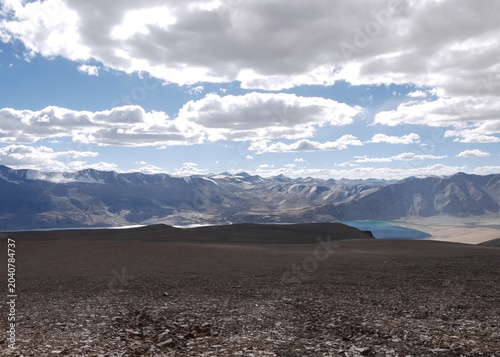 Cuadro en lienzo A vast panoramic view of a deep blue alpine lake and barren mountain ranges under a dramatic cloudy sky in Ladakh, Himalayas