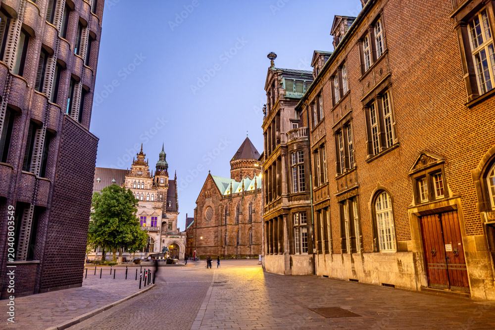 Obraz premium Bremen by night, with glowing streets, historic facades, and reflections creating a peaceful urban atmosphere in the heart of northern Germany.