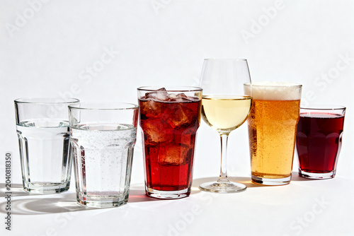 Assortment of refreshing beverages including water, soda, wine, beer, and juice in various clear glasses