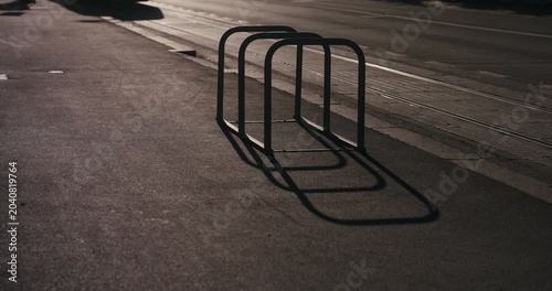 Empty bicycle rack casting long shadows on a city street in Zagreb Croatia during sunset light.