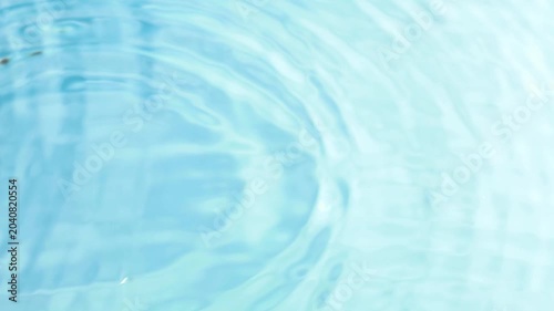 raindrops fall on a flat, clean surface of water and form circles on the water