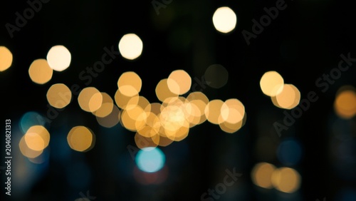 Blurred warm golden bokeh city lights background at night.