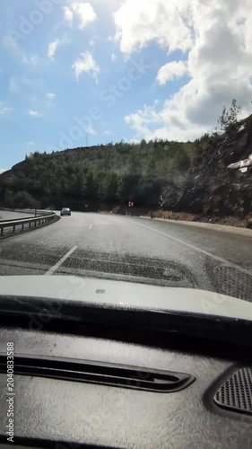 Timelapse of car moving on serpentine road among trees and mountains at sunny summer day filmed from inside. closeup vertical view of a route with signs. travelling in warm country by auto. trip