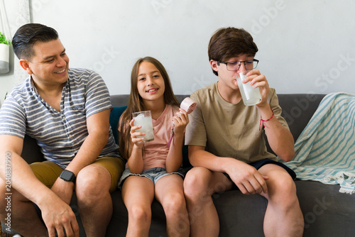 Obraz na plátně Family beat the summer heat at home, staying cool with cold drinks and a portabl