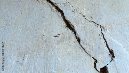Obraz na płótnie Close-up of a cracked concrete wall with visible fractures and damaged plaster s