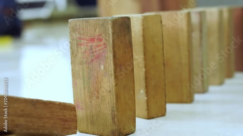 Wooden domino blocks falling down in a chain reaction video footage