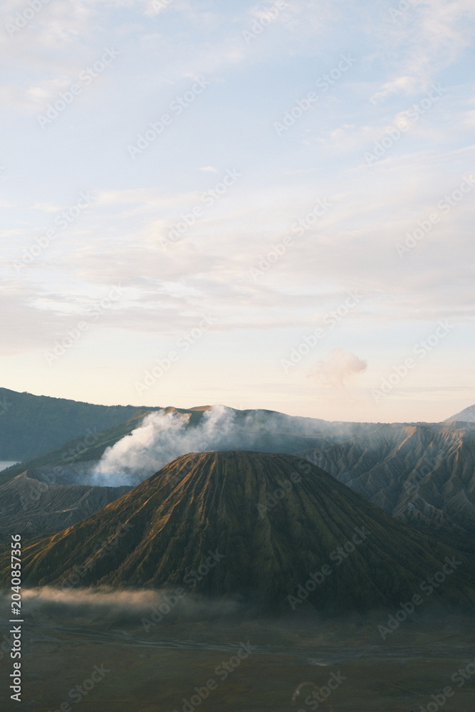 Obraz premium Mount Bromo Volcano at Sunrise with Dramatic Mountain Landscape