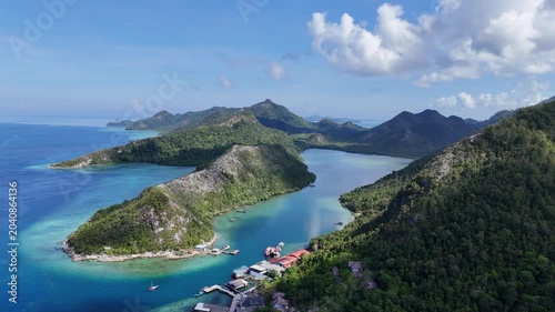 Aerial view of a tropical island bay with turquoise water and lush green mountains