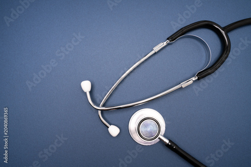 Blue medical stethoscope on dark background with copy space