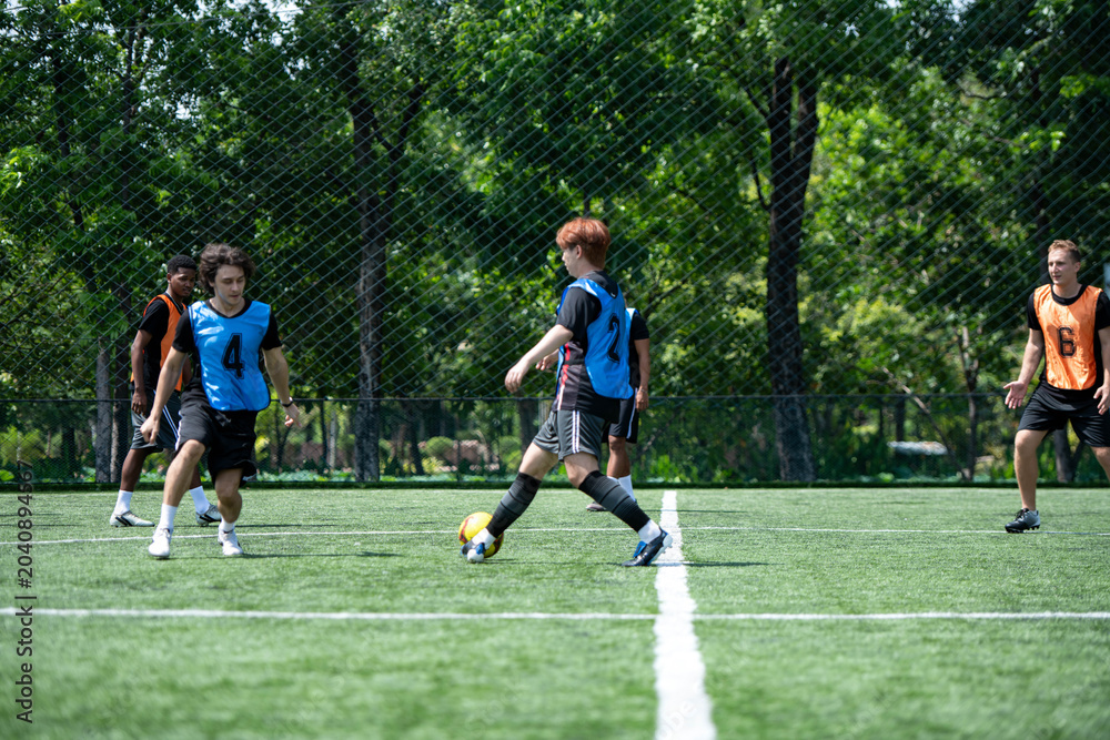 Obraz premium Soccer coach leading a practical training drill with players on an outdoor football field