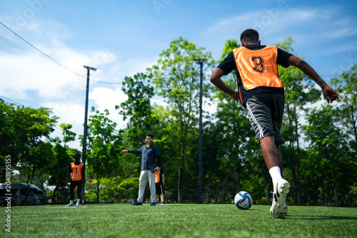 Valokuva A young football players are practicing free kicks while the opposing team forms