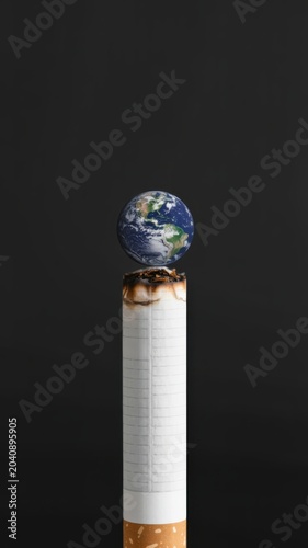 Burning cigarette with planet earth on top against dark background symbolizing pollution climate change and environmental danger