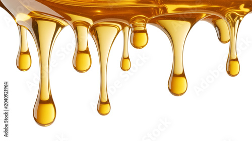 Viscous golden liquid dripping with light reflections on white