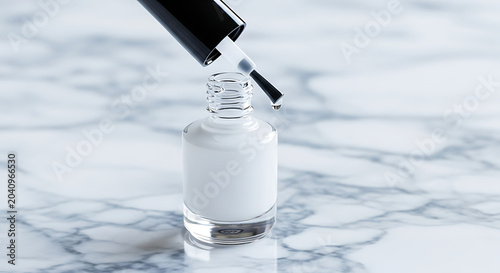 A hand holding a paintbrush dipping into a cup of white paint on a white surface