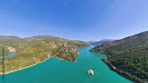 pilot view, Aerial low altitude flight over Lake Castillon with Alpine mountain reflections on calm water, Provence, France