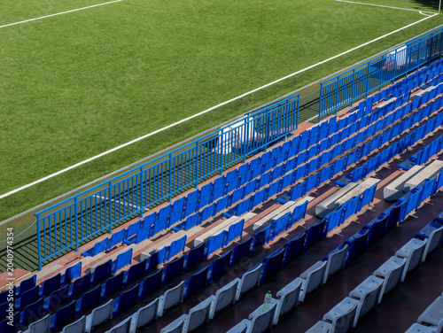 Blue and white stadium seats beside soccer field