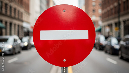 No Entry Traffic Sign on City Street Background with Blurred Cars