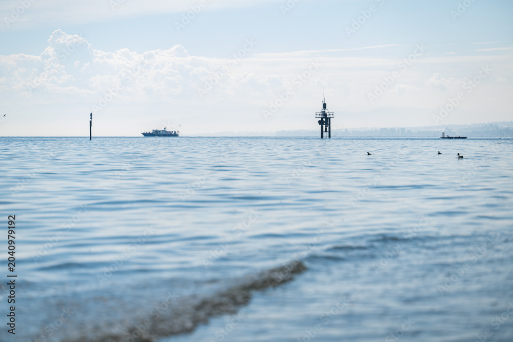 Fototapeta premium Lake constance water with distant boats, buoys, and ducks