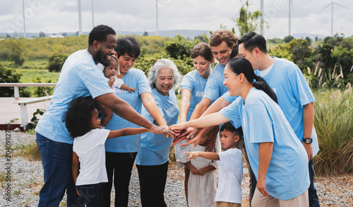 Multiracial family gathers outdoors, hands joined in unity