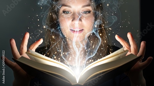Woman looking at glowing magical book with ethereal light