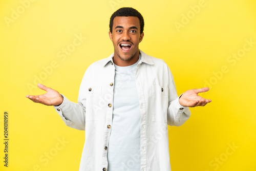 Bild auf Leinwand African American handsome man on isolated yellow background with shocked facial