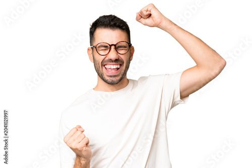 Cuadro en lienzo Young handsome caucasian man over isolated chroma key background celebrating a v