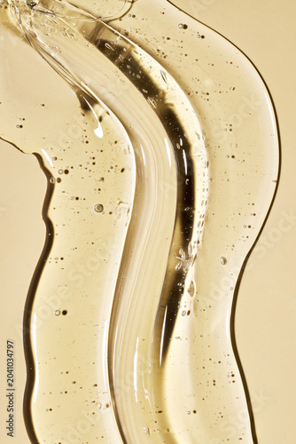 Clear yellow cosmetic gel with bubbles creating a flowing, wavy texture for beauty and scientific concepts