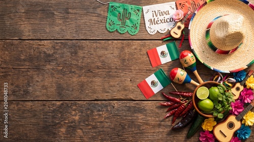 Mexico Independence Day flat lay with papel picado sombrero and maracas on rustic wood